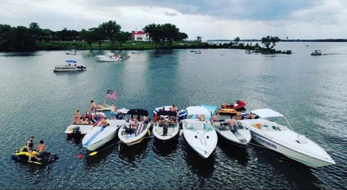 Multiple boats tied together floating out on the water 